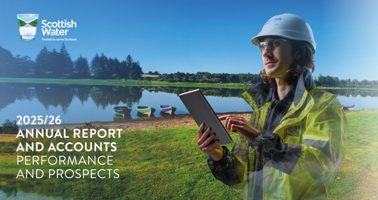 Scottish Water male employee wearing hi viz and hat holding an ipad against a backdrop of a reservoir with three boats at the water's edge on a sunny day.