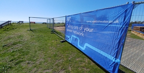 A blue sign on a fence