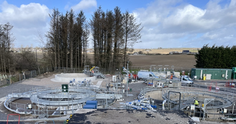 A wastewater treatment site with treatment tanks in the foreground