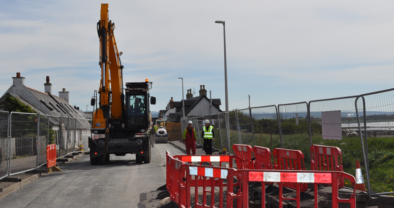 An excavator moving along Stuart Street in Ardersier during installation of the new rising main in 2017