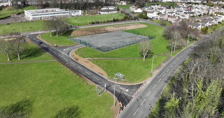 An access road connecting a school and site compound to the main road is shown from above