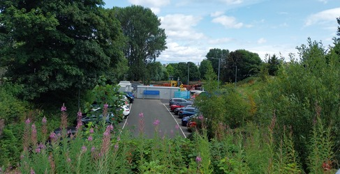 A construction site is shown at the end of a car park
