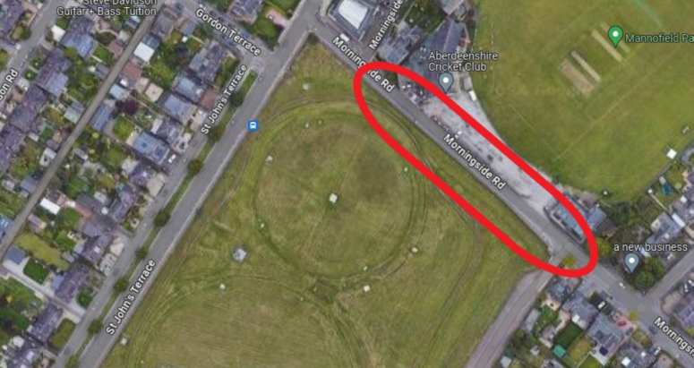 Aerial view of Mannofield Park near Aberdeenshire Cricket Club, highlighted by an oval indicating a specific area on the road and nearby grassy fields surrounded by various local businesses on adjacent streets.