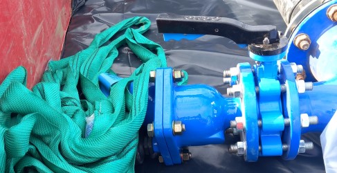 Image of bright blue water main being installed in the ground