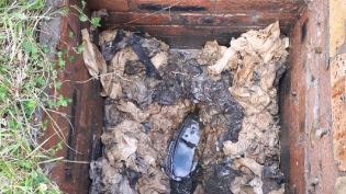 A drain blocked with rags and wipes