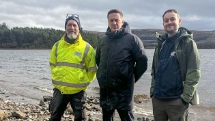2x members of the Scottish Water Land Strategy Team pictured either side of the Watch Commander from Scottish Fire and Rescue, pictured on the shore just in front of Gladhouse Reservoir. Scenic background.