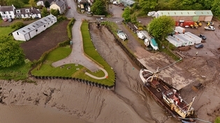 Drone footage of harbour with water and boats docked