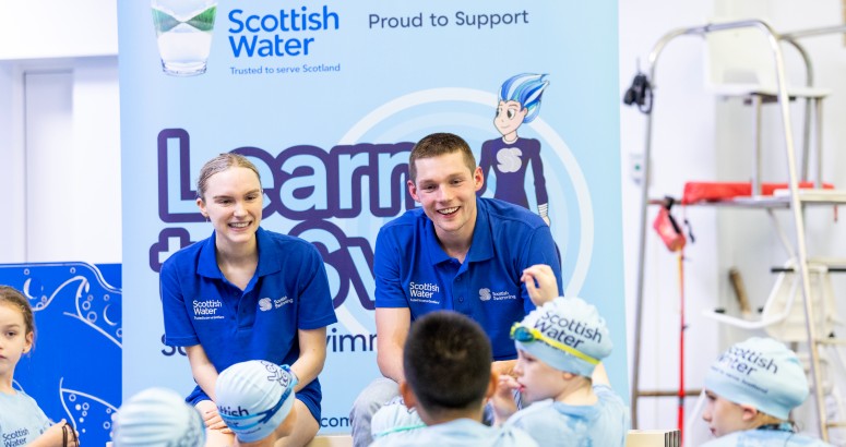 Toni Shaw and Duncan Scott pictured at front of a Q&A with kids sitting on floor facing them. 