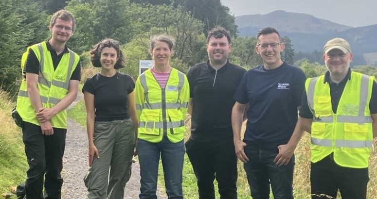 Scottish Water Volunteers and Ranger posing for team pick with Carron Valley Reservoir woodland in backround