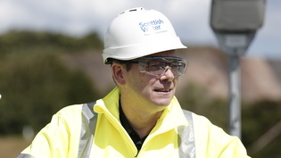 Scottish Water CEO Alex Plant in hard hat and hi vis PPE outside.