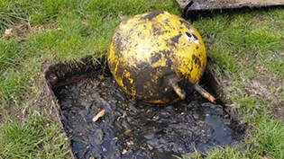 dirty yellow space hopper in open blocked sewer