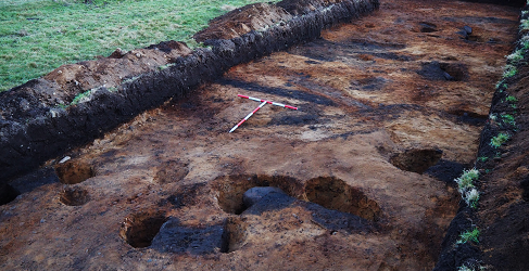 Iron Age roundhouse during excavation showing arc of post settings